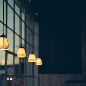 Amber glass pendant lights glowing warmly beside a dark window