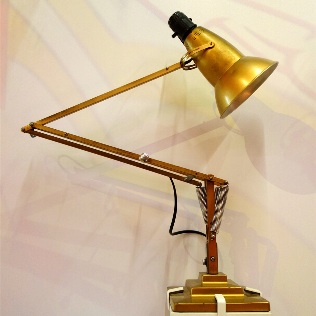 Brass articulated desk lamp with a sprung arm and black weighted base