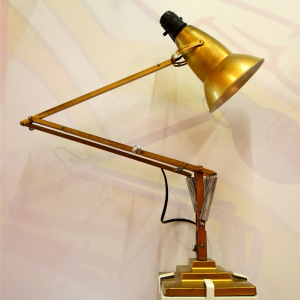 Brass articulated desk lamp with a sprung arm and black weighted base