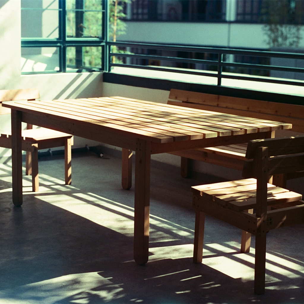 Slatted solid wood bench and chairs in warm afternoon light