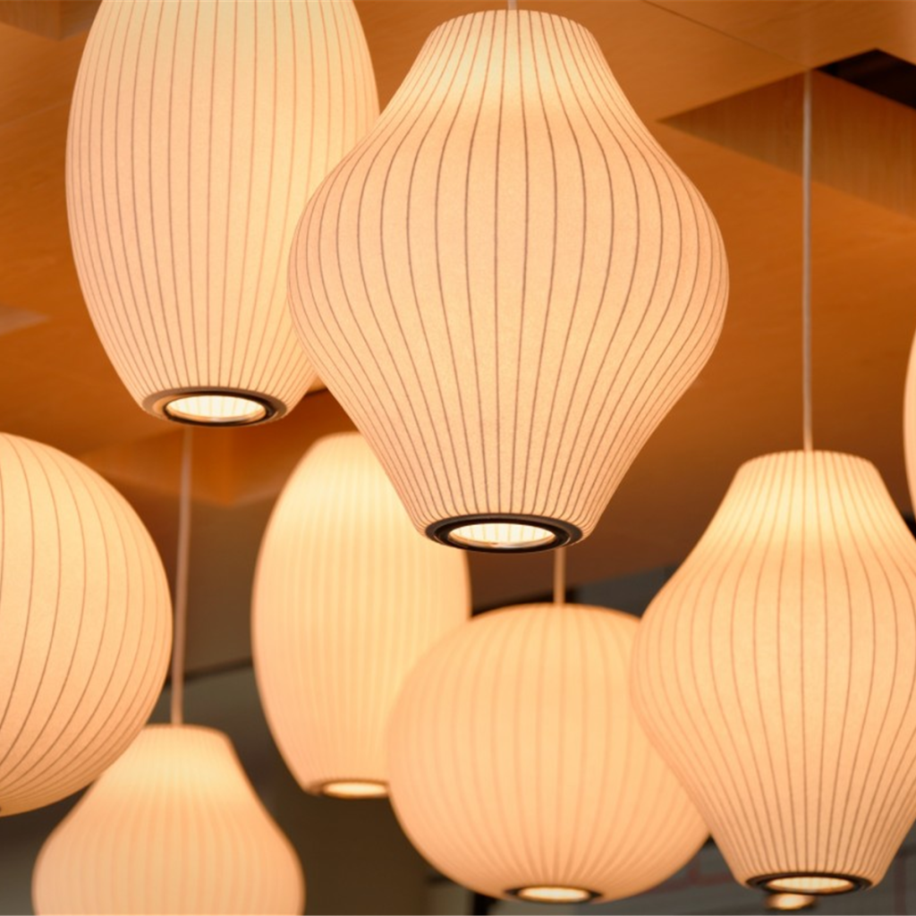 Ribbed paper lantern pendant lights hanging in a warm row